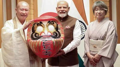 pm modi is presented with a daruma doll in japan